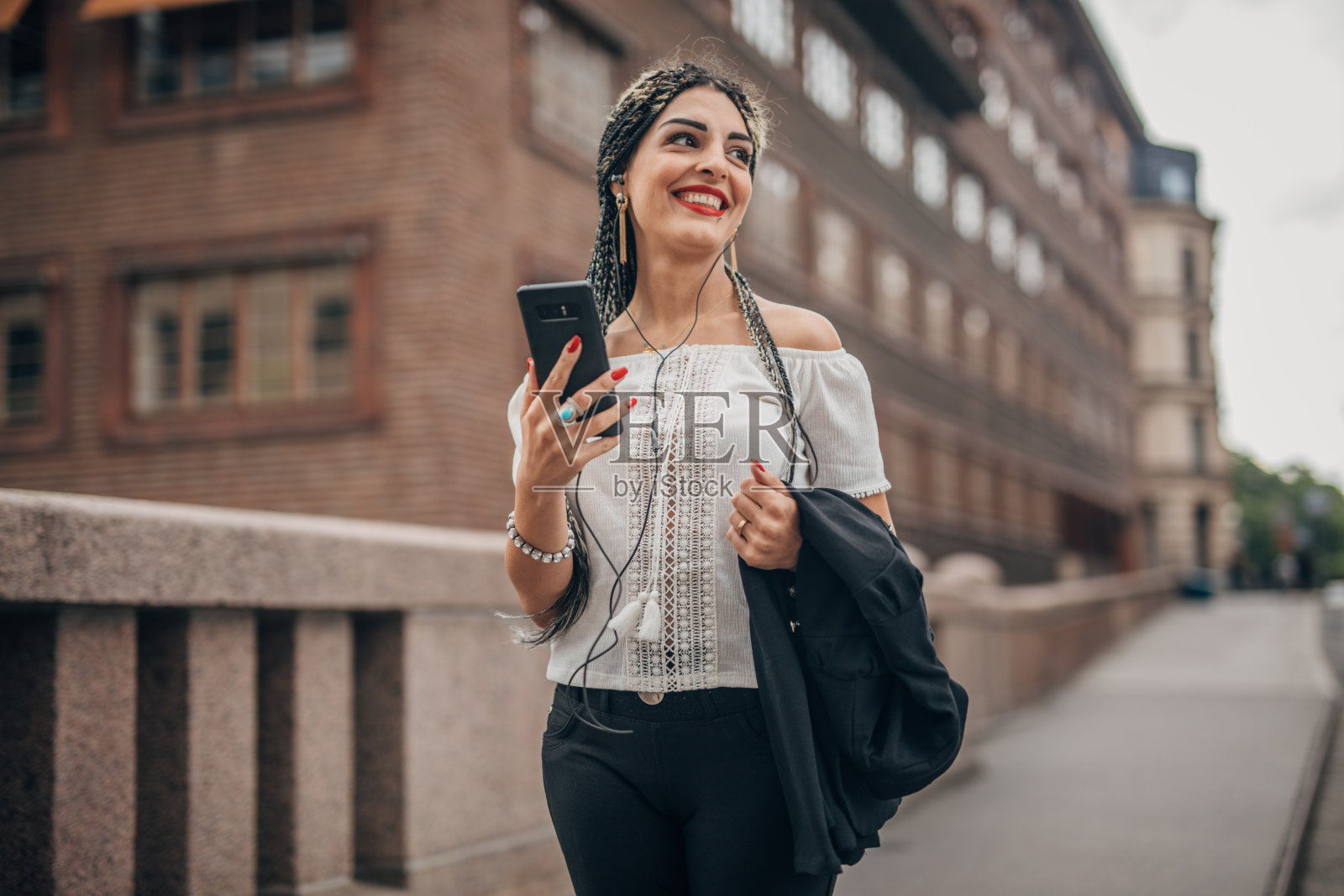 年轻女人在城市街道上使用智能手机照片摄影图片