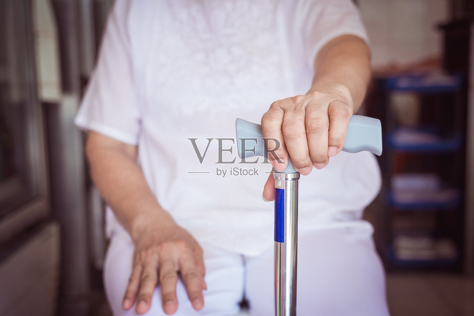 亚洲老年妇女手持拐杖的特写照片摄影图片