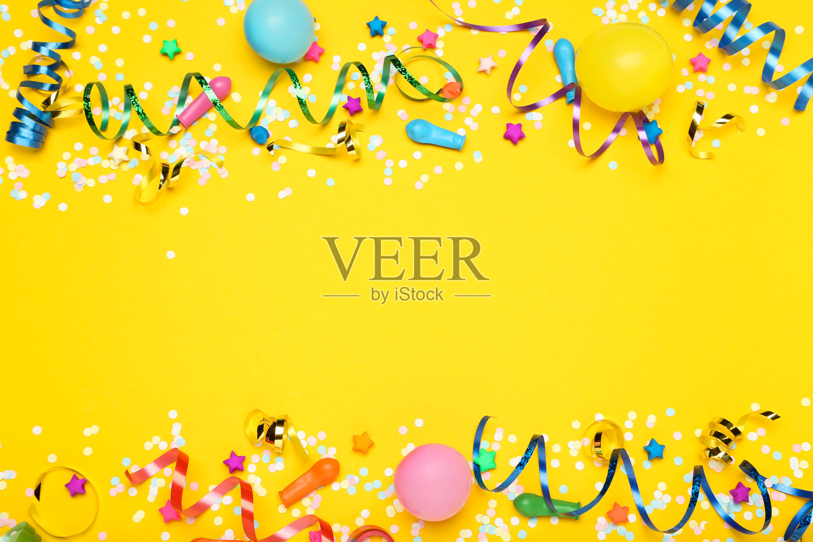 黄色背景上有橡胶气球、纸星星和五彩纸屑的彩色丝带照片摄影图片