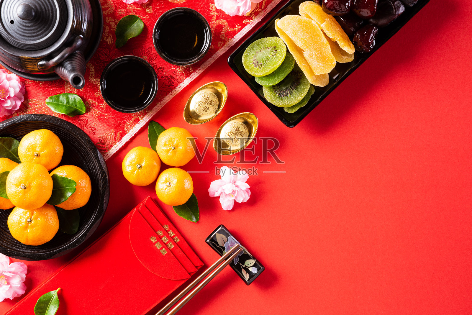 中国新年节日的装饰品是红色背景上的橙色和金元宝或金块。文章中“福”字指的是财运、财运、财源滚滚。照片摄影图片