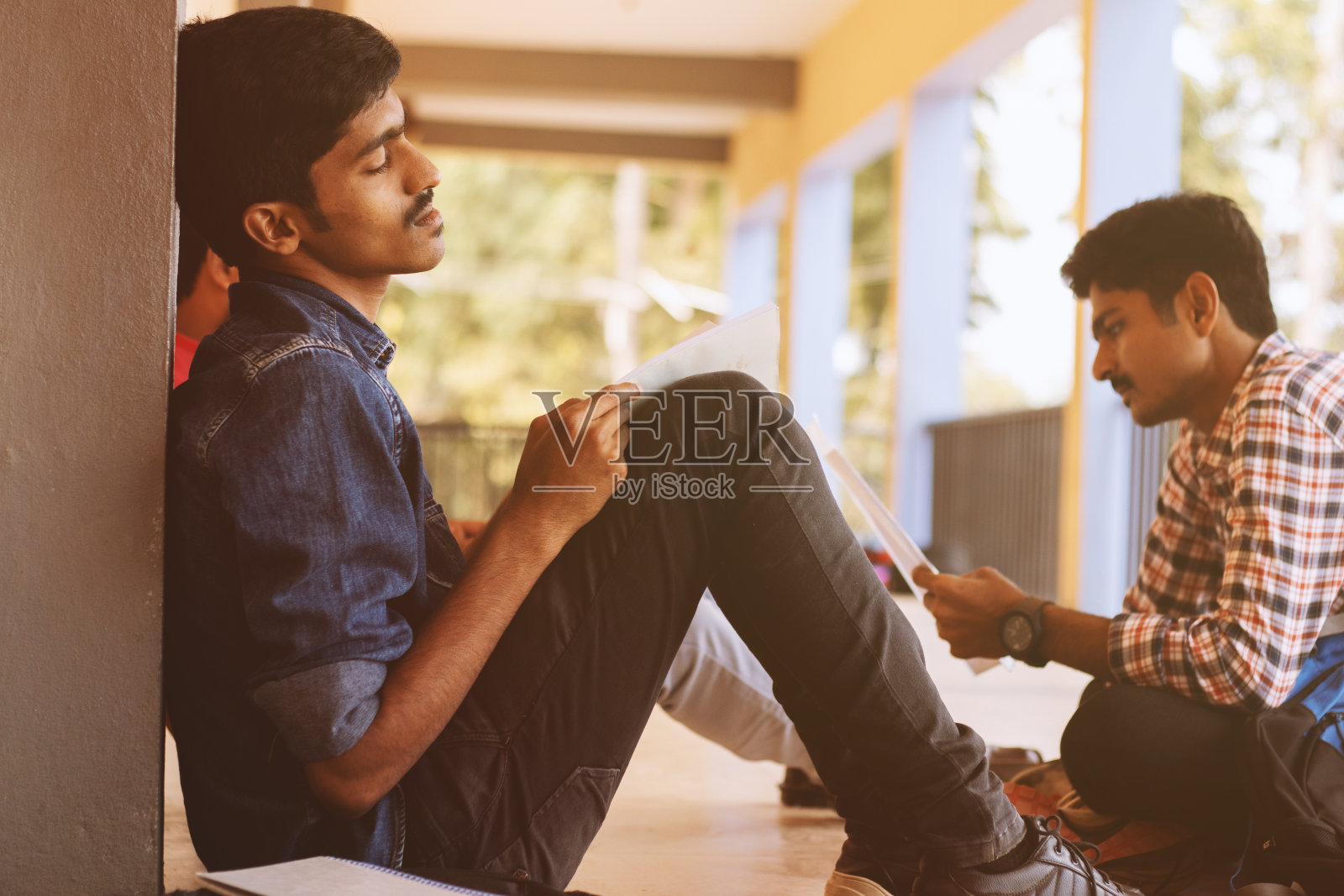 大学生因缺乏兴趣、疲倦或生病而睡在校园里。照片摄影图片