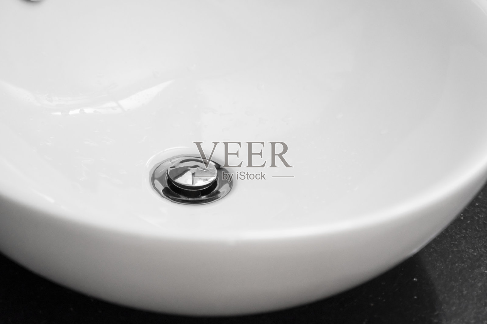 浴室内部与白色圆形水槽和铬水龙头在一个现代浴室。照片摄影图片