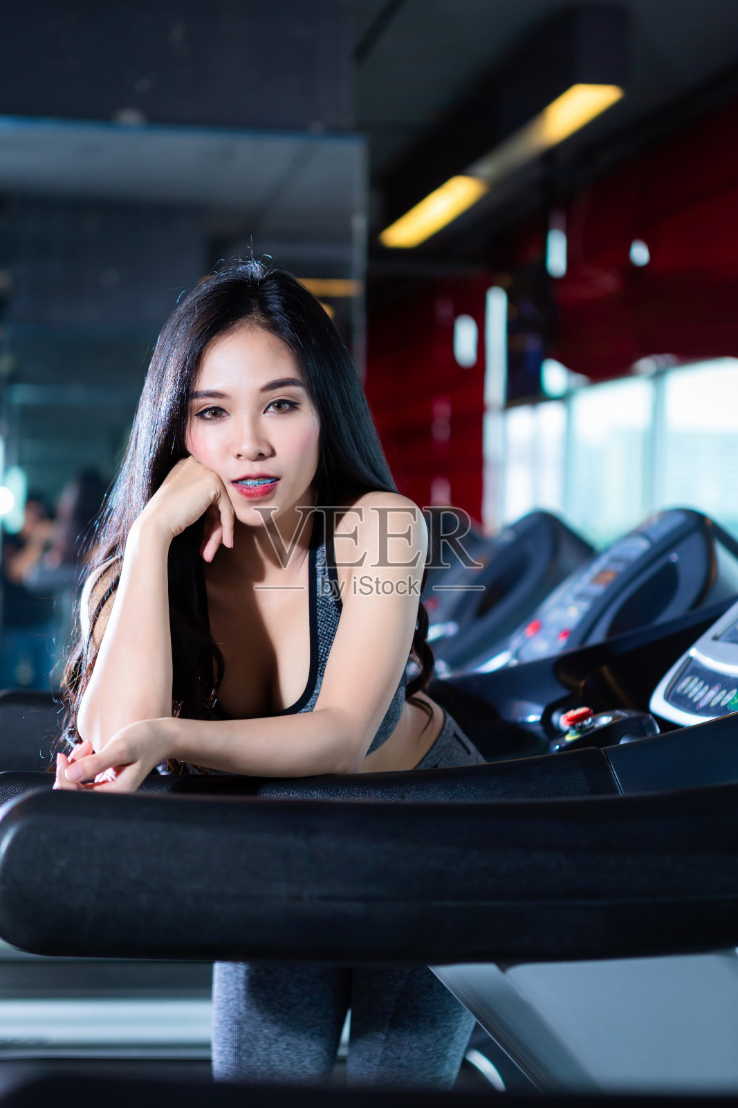 亚洲女性在健身房跑步机上运动照片摄影图片
