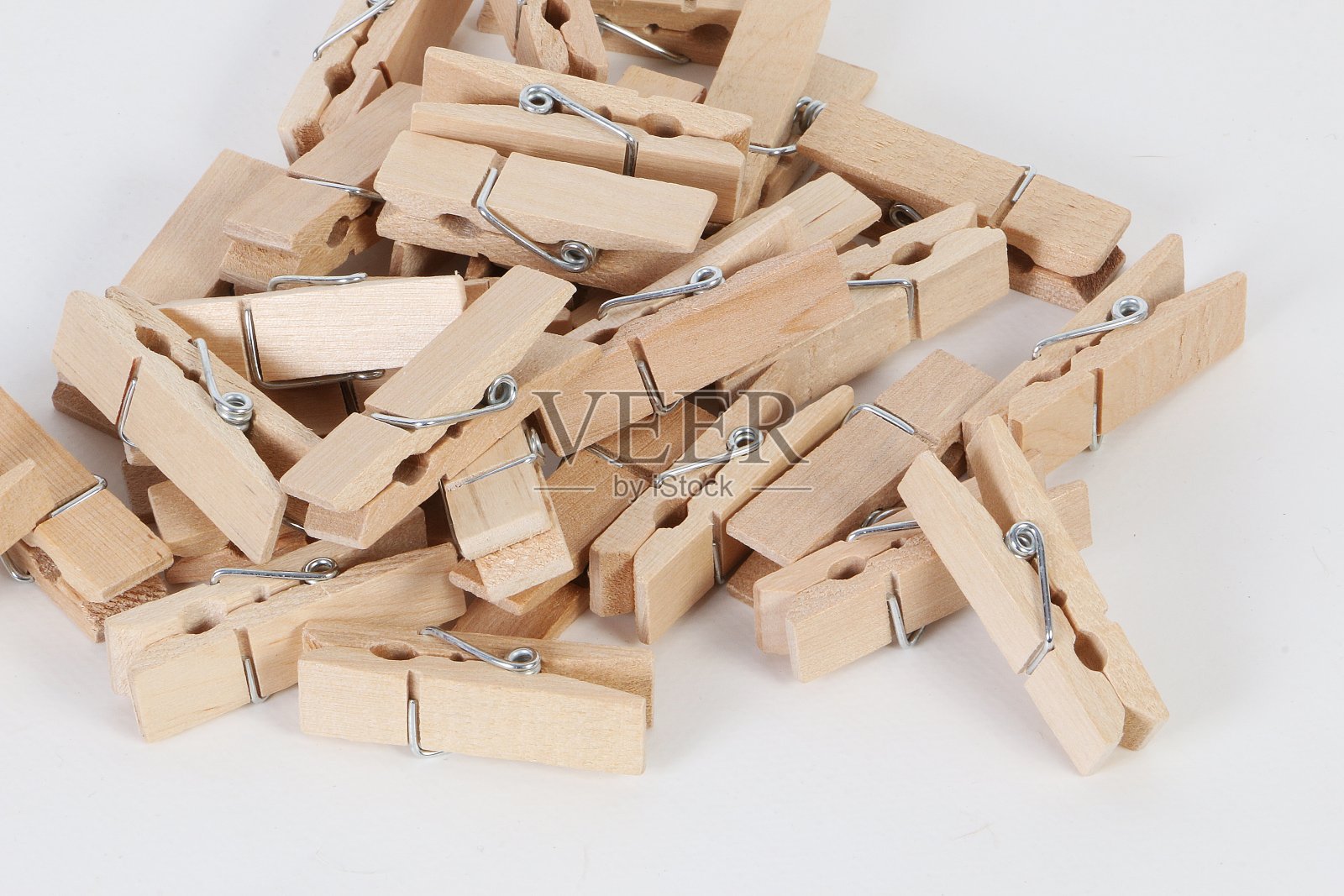 白色背景上的一堆小木衣夹照片摄影图片
