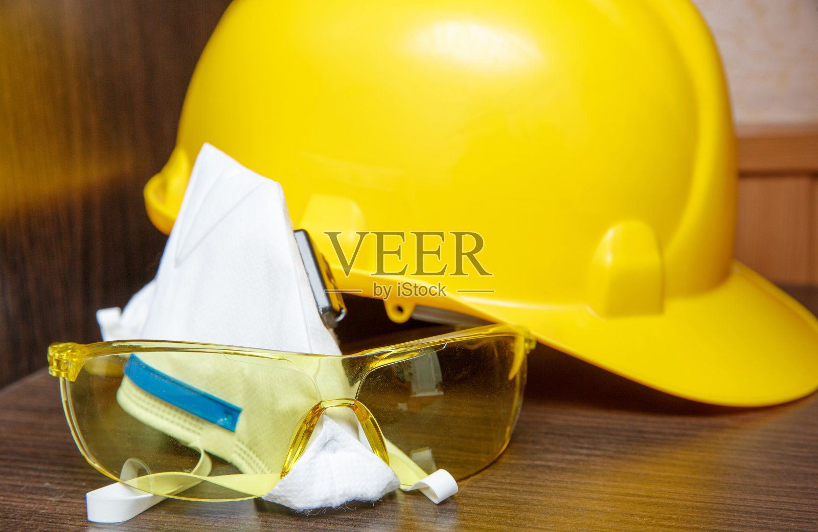 安全眼镜是黄色白色防尘保护。防护头盔照片摄影图片