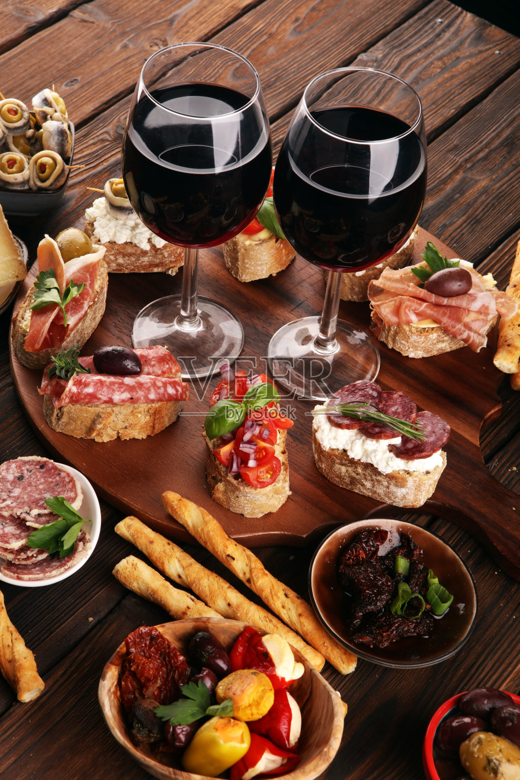 开胃菜餐桌与意大利小吃和葡萄酒在玻璃杯。Brushetta或正宗的传统西班牙小吃,奶酪品种照片摄影图片