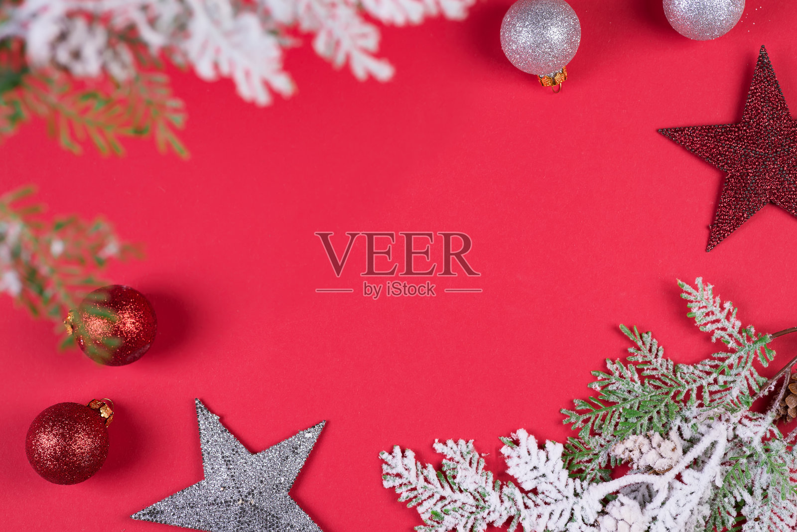 圣诞树枝在雪中,圣诞玩具在红色的背景,拷贝空间照片摄影图片