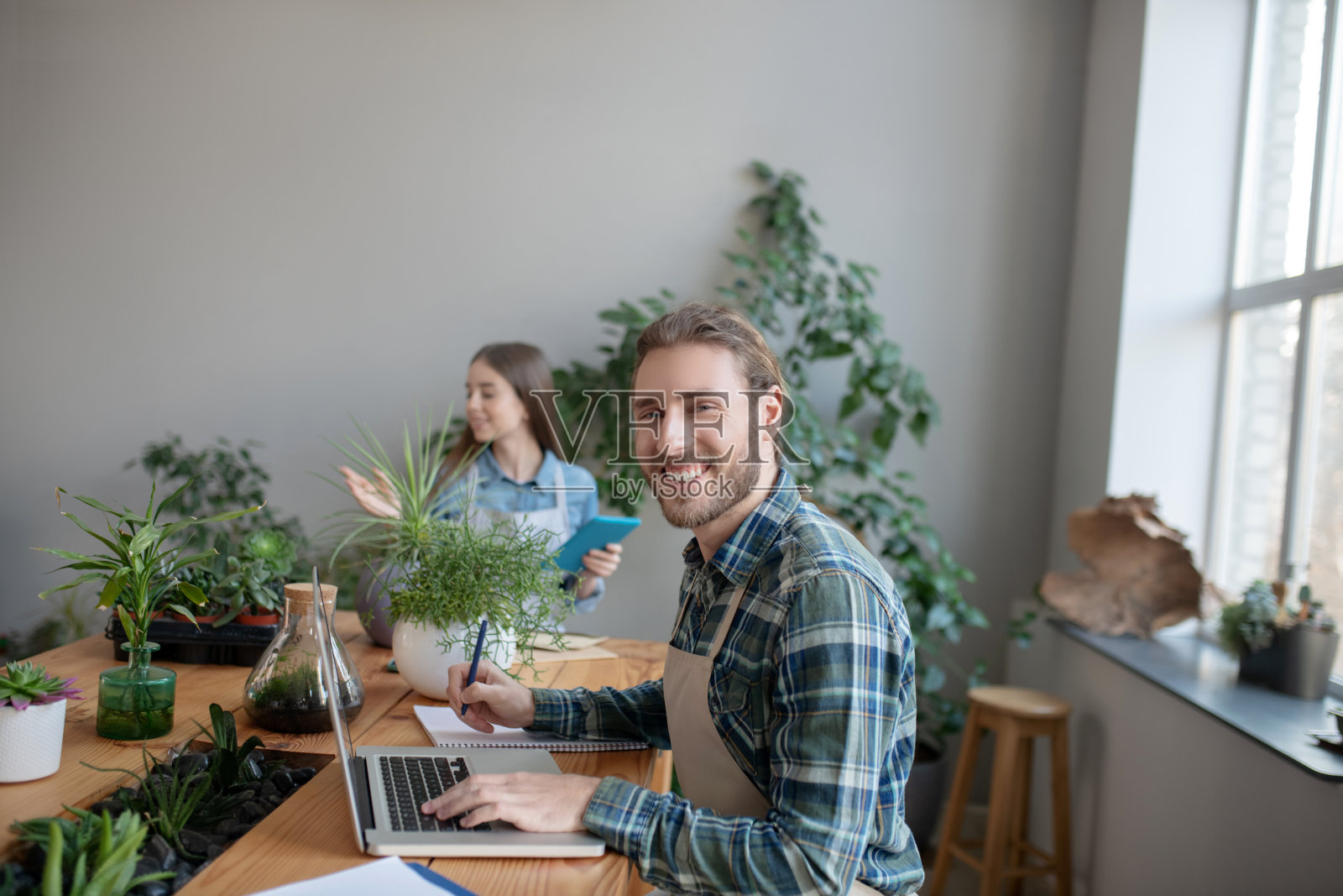 微笑的男人从笔记本电脑上记笔记照片摄影图片