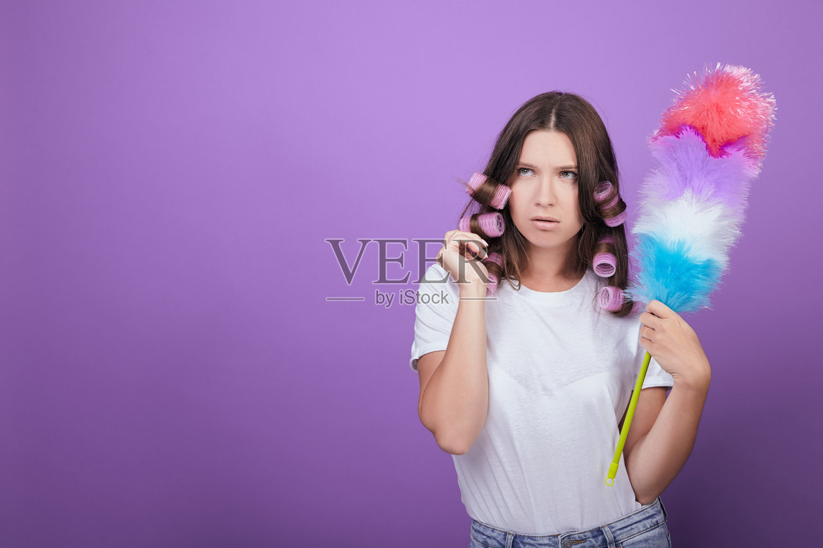 美丽的黑发女子拿着除尘刷和粉色卷发器照片摄影图片