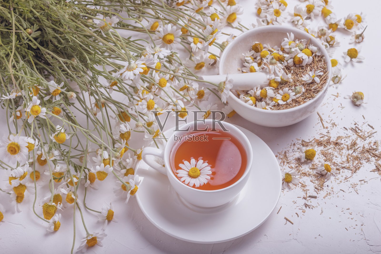 乡村静物——一杯泡好的甘菊茶,背景是一束雏菊照片摄影图片