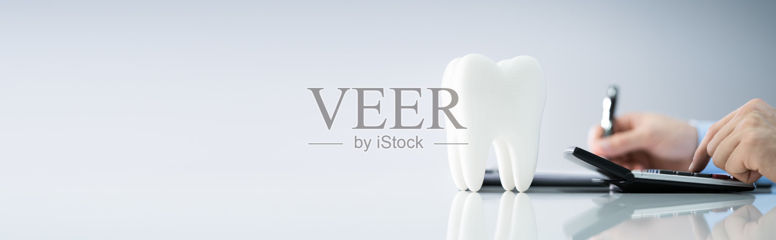 人员在白色桌子上牙齿模型附近计算费用照片摄影图片