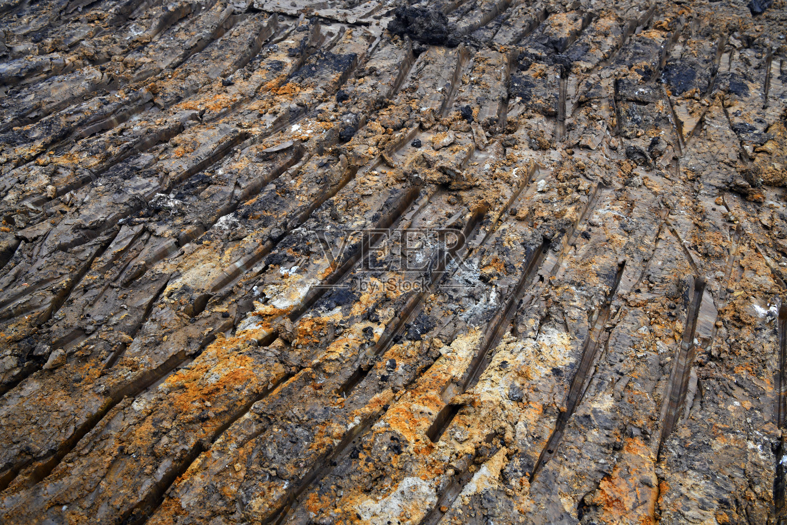 推土机在泥里留下了有趣的痕迹。美丽的泥的质地和颜色。泥泞的背景。照片摄影图片