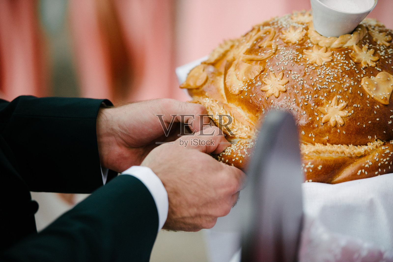 新郎掰下一块婚礼面包照片摄影图片