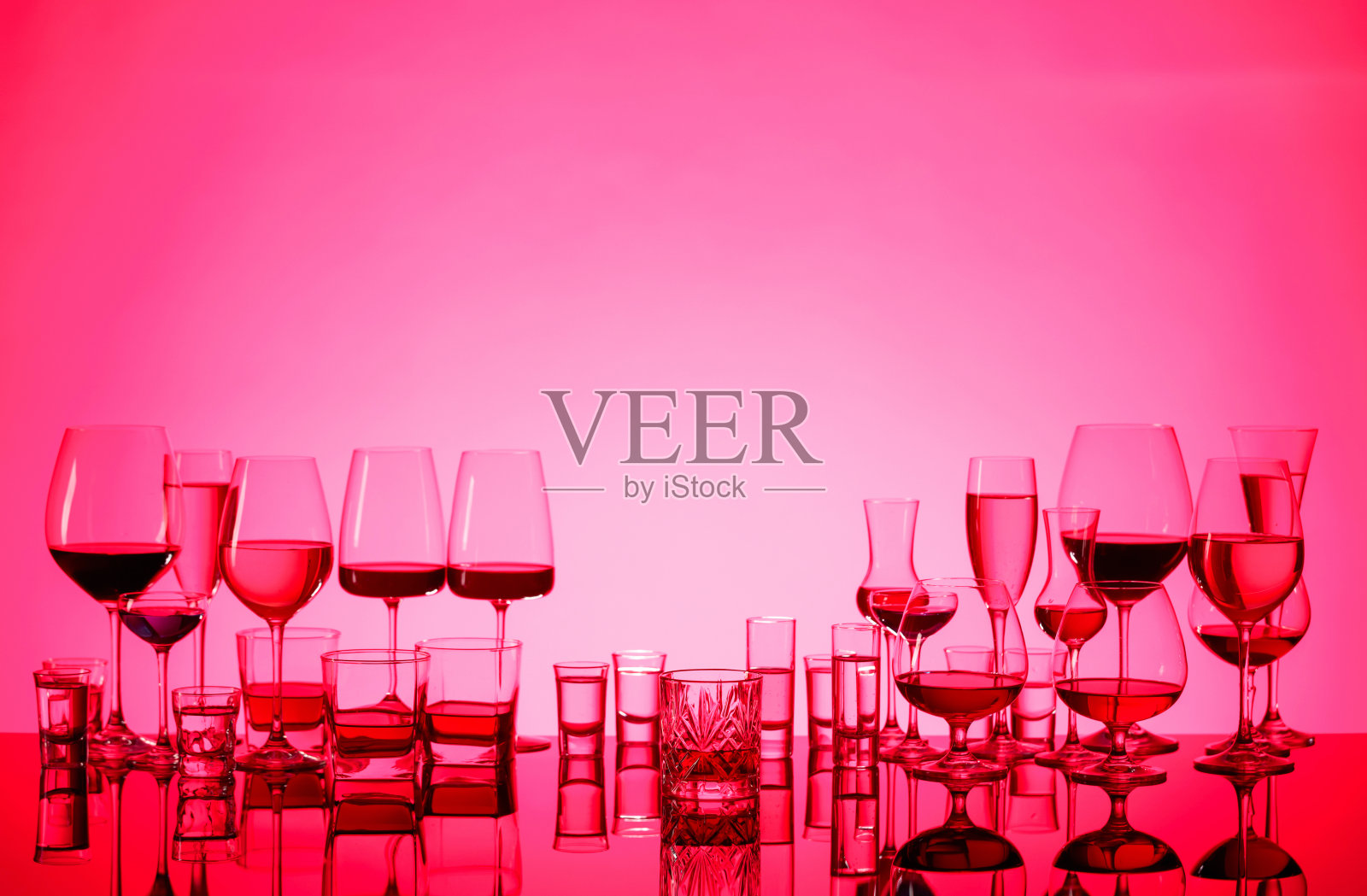 一套各种酒精饮料在玻璃杯上的红色背景。照片摄影图片