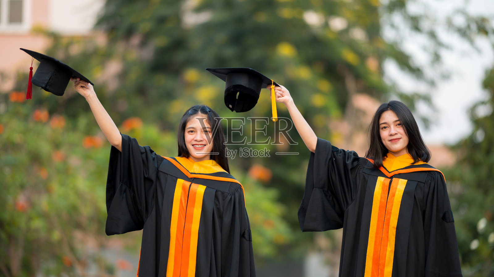 女毕业生穿着黑色长袍和黄色流苏等着参加大学的毕业典礼。照片摄影图片