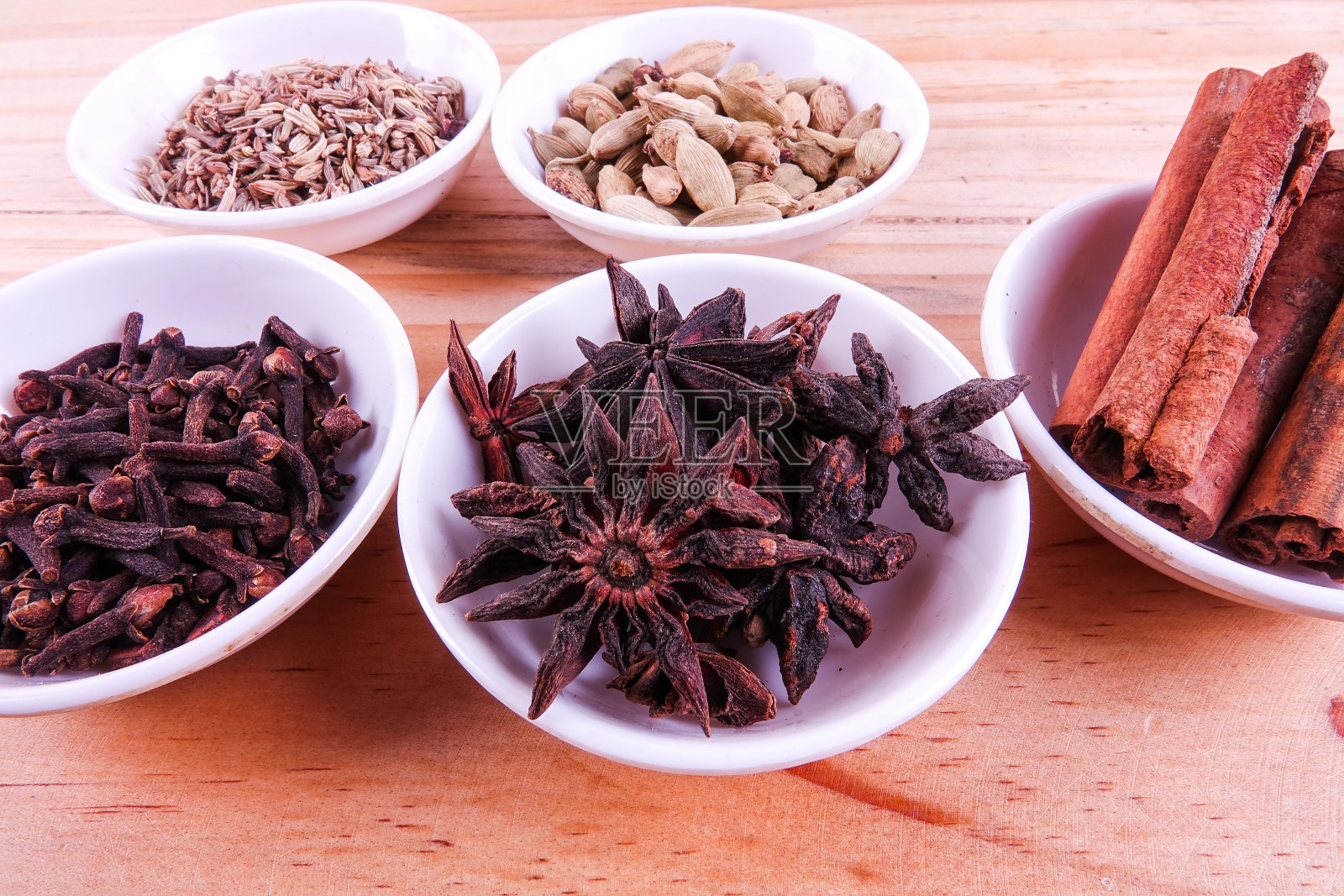 木质背景上放着各种印度香料。照片摄影图片