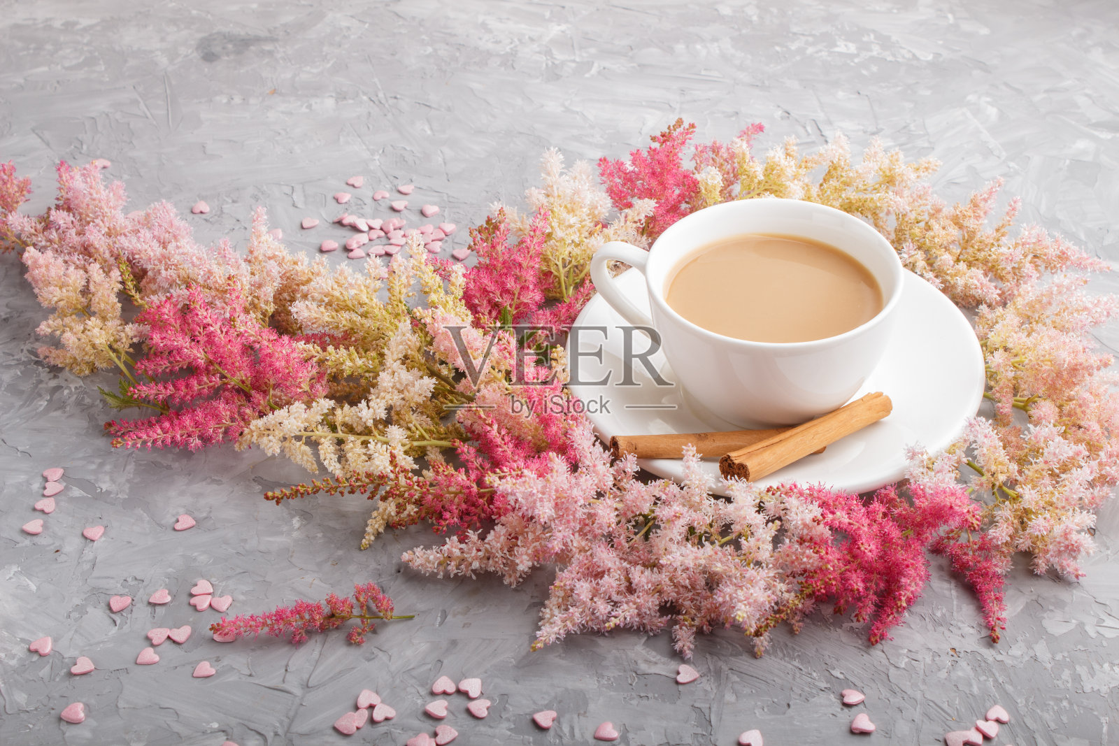 粉红色和红色的落新娘子花和一杯咖啡在灰色的混凝土背景。早晨,春天,时尚作文。侧视图,关闭u照片摄影图片