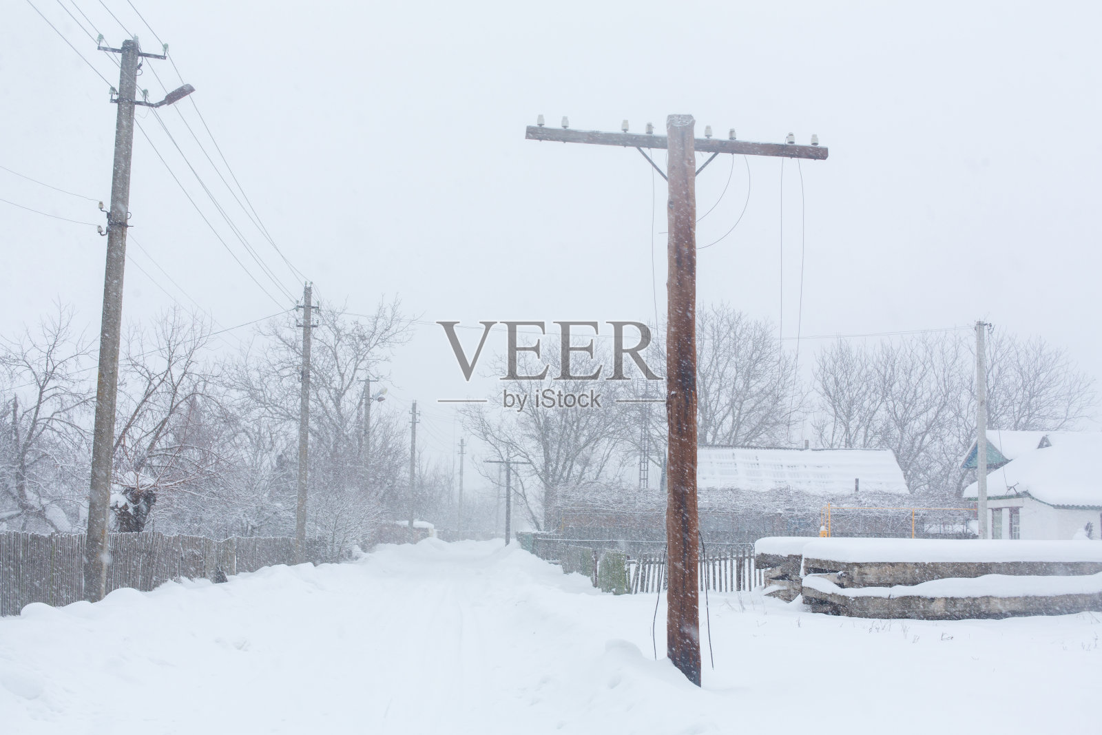 冬天,乡村的街道被雪覆盖。雪暴风雪照片摄影图片