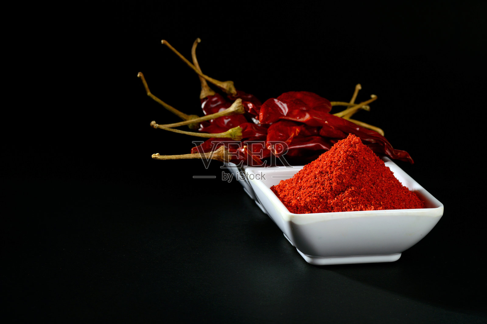 凉粉与红凉粉放在白色盘子里,干辣椒放在黑色背景上照片摄影图片