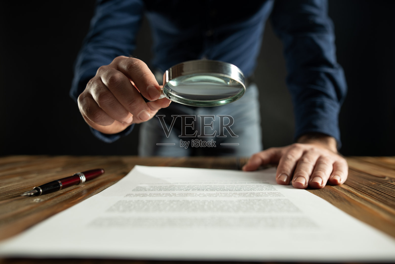 签署前用放大镜阅读合同的商人照片摄影图片