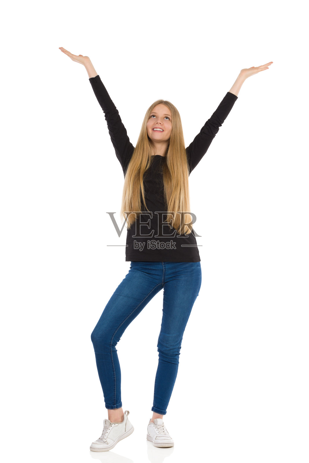 微笑的少女站立着举起双臂仰望照片摄影图片