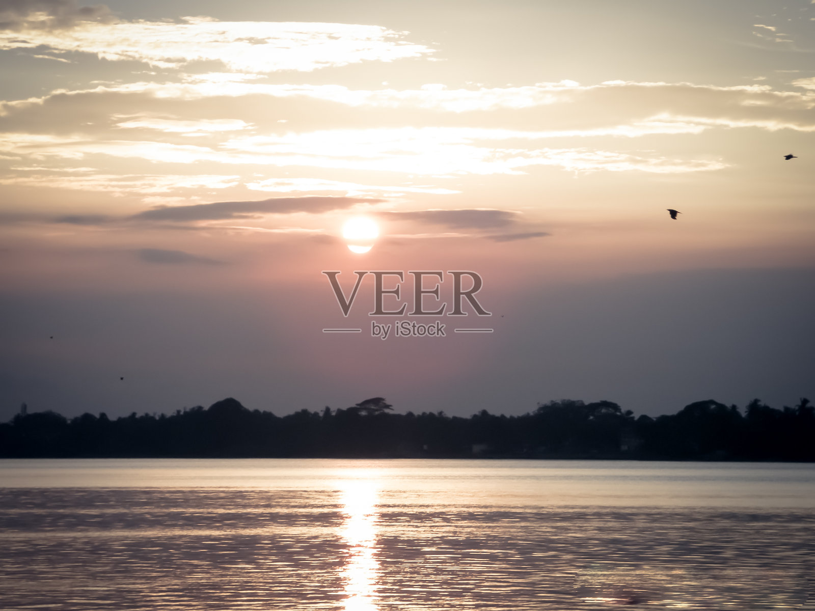 太阳在晚上的天空中,就在太阳在西方落下之前。傍晚日落时天空暗沉,颜色红黄。夏天的黄昏时间。景观风景。美丽的自然背景。照片摄影图片