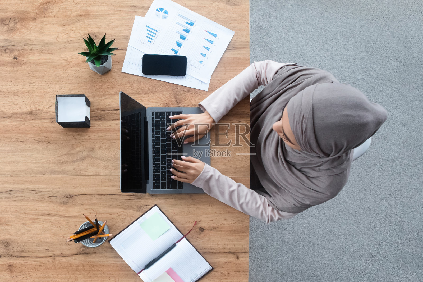在办公室用笔记本电脑工作的穆斯林妇女俯视图照片摄影图片