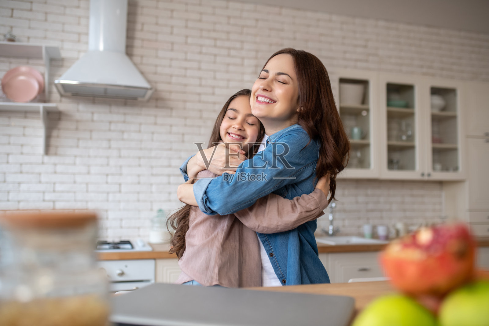 母女相拥,闭着眼睛照片摄影图片
