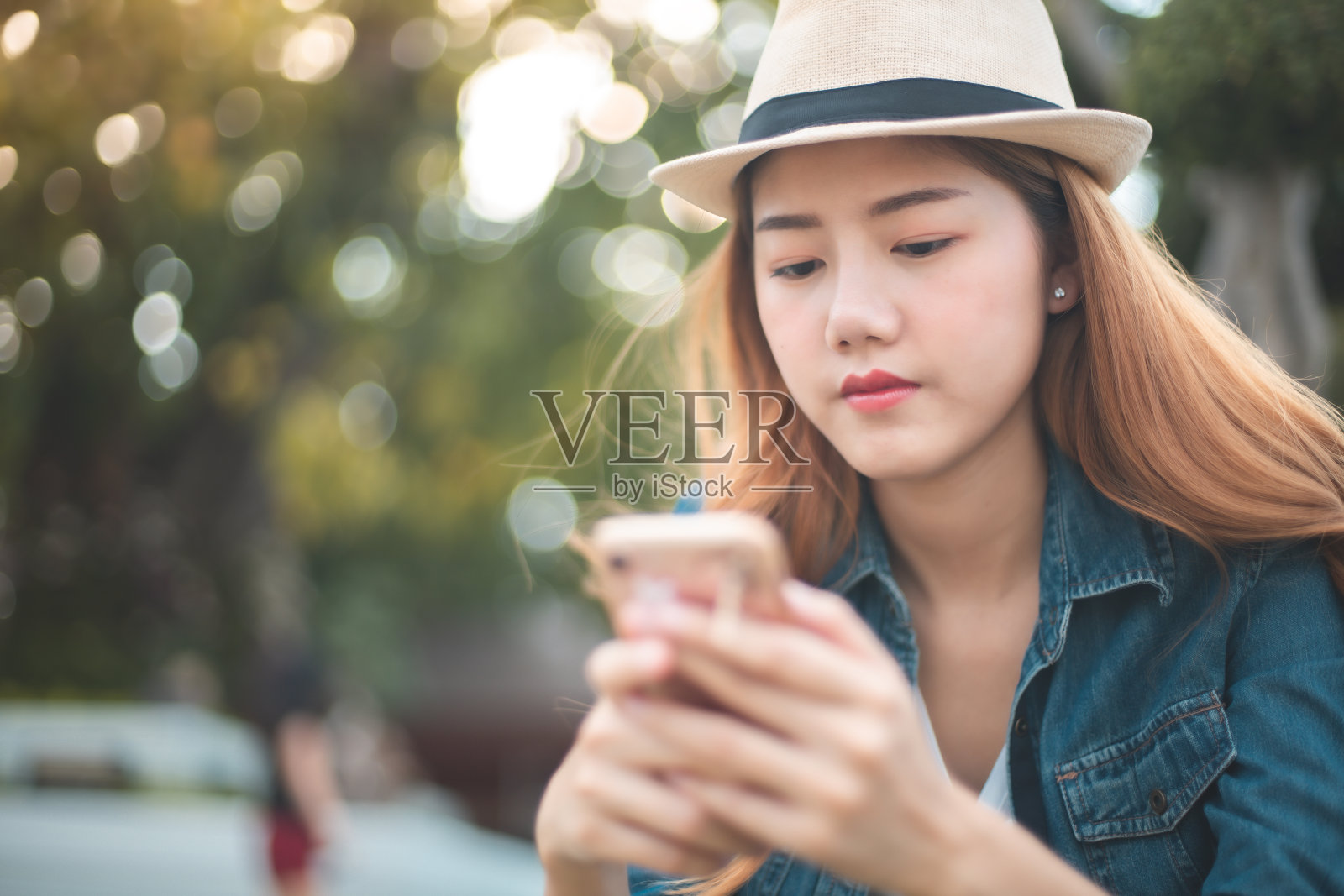 女人在阳光明媚的夏日花园里使用手机照片摄影图片