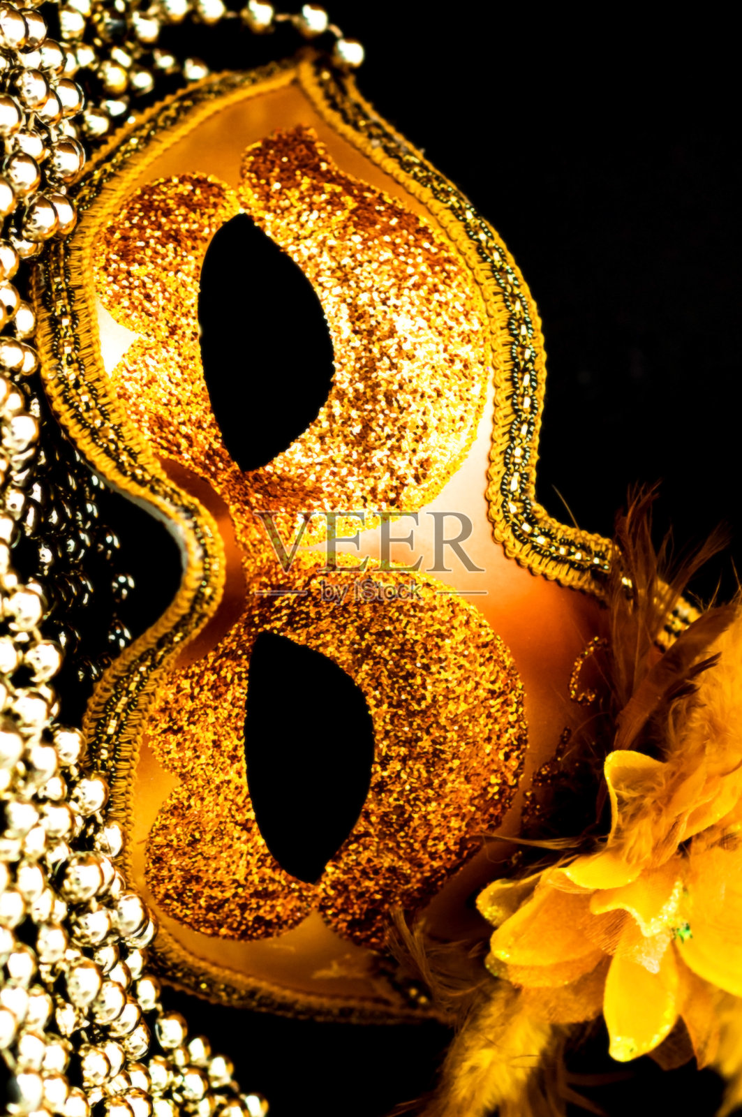 金色狂欢节面具特写,黑色背景与银色珠子点缀照片摄影图片