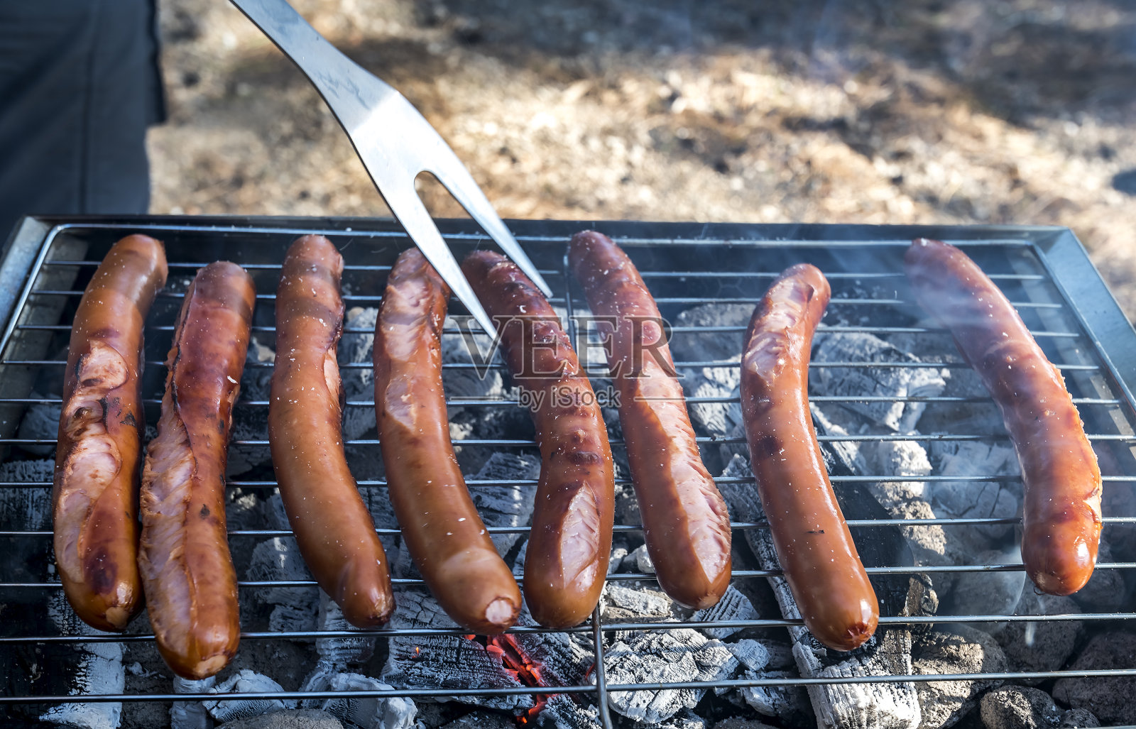 在火焰烧烤上烤香肠,在休息区野餐,选择焦点照片摄影图片