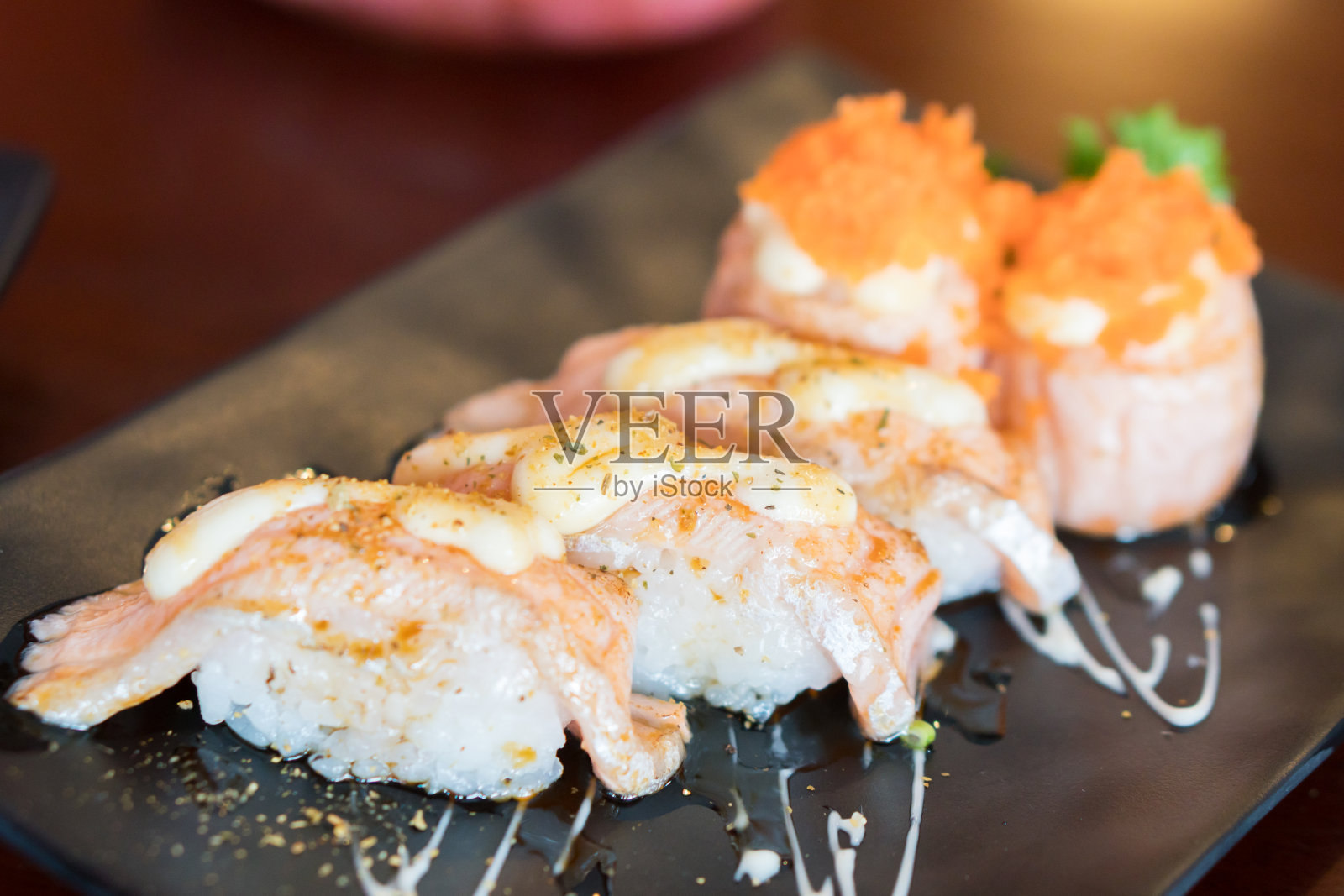 新鲜的鲑鱼寿司在黑色的日本盘子照片摄影图片