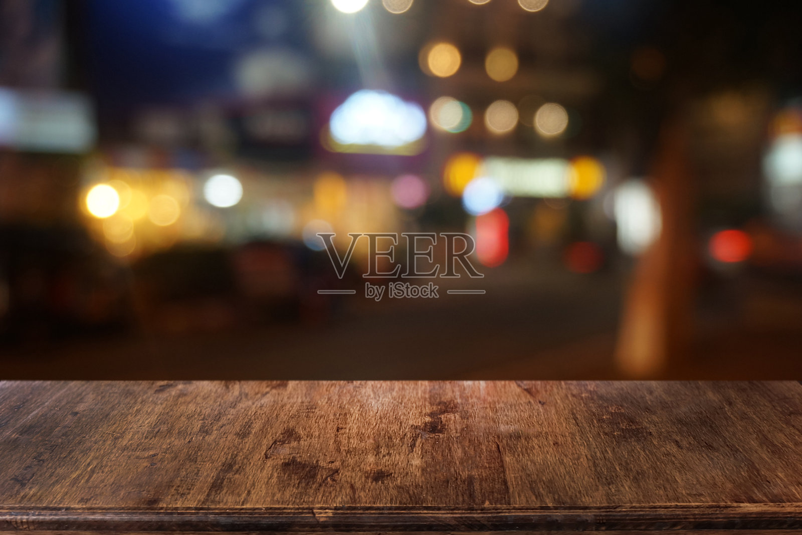 空荡荡的深色木桌前面抽象模糊的散景餐厅背景。可用于展示或蒙太奇您的产品。模拟空间。照片摄影图片