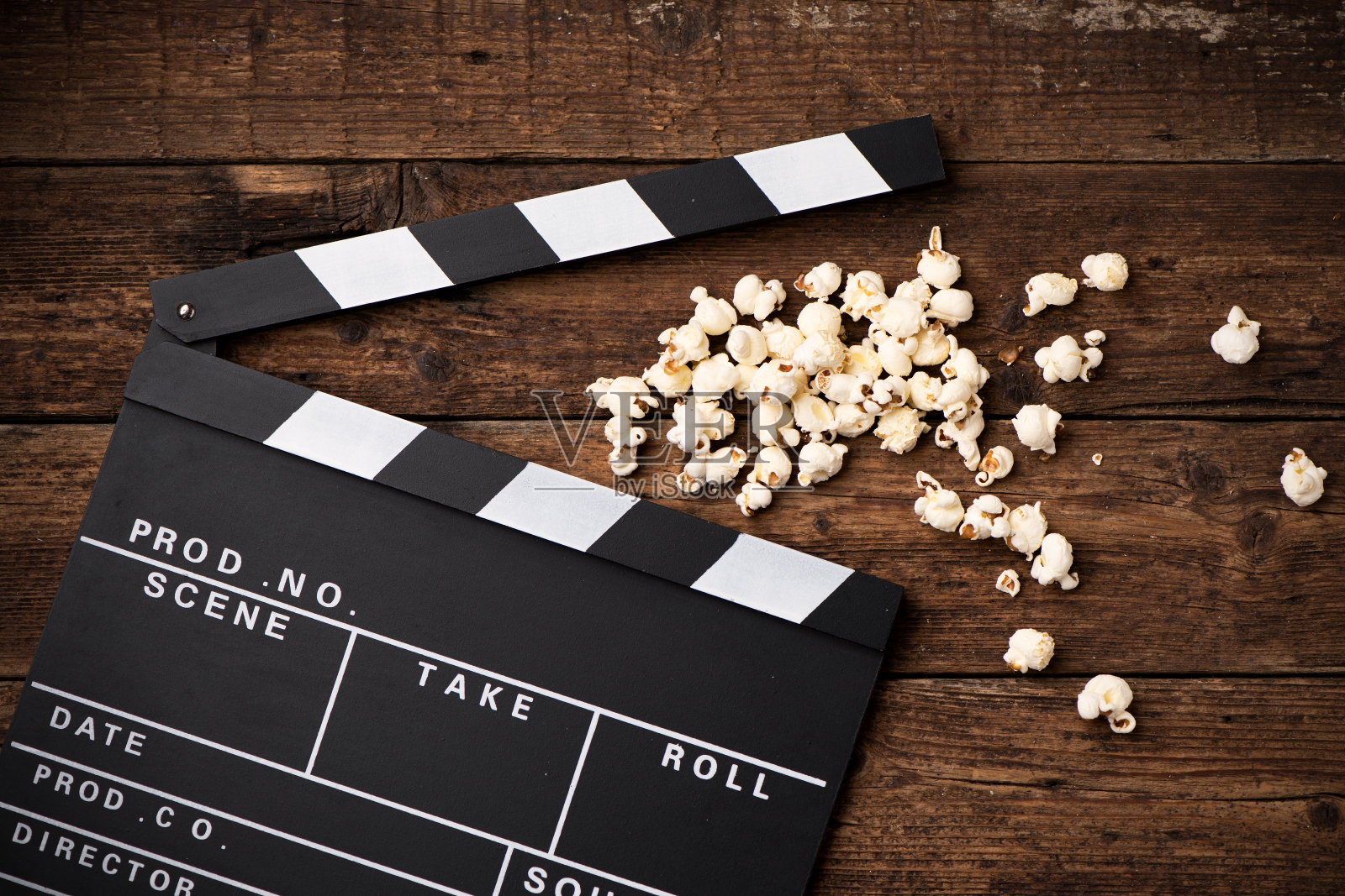 拍板和爆米花在木制背景上照片摄影图片