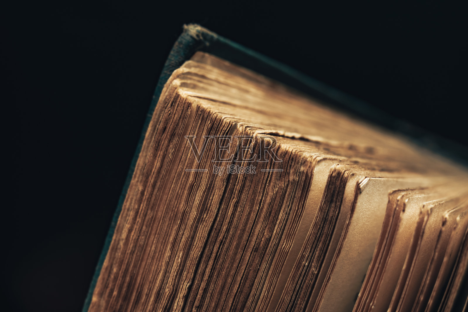 特写古书拍摄的黑色背景。这本书的条件很差。照片摄影图片