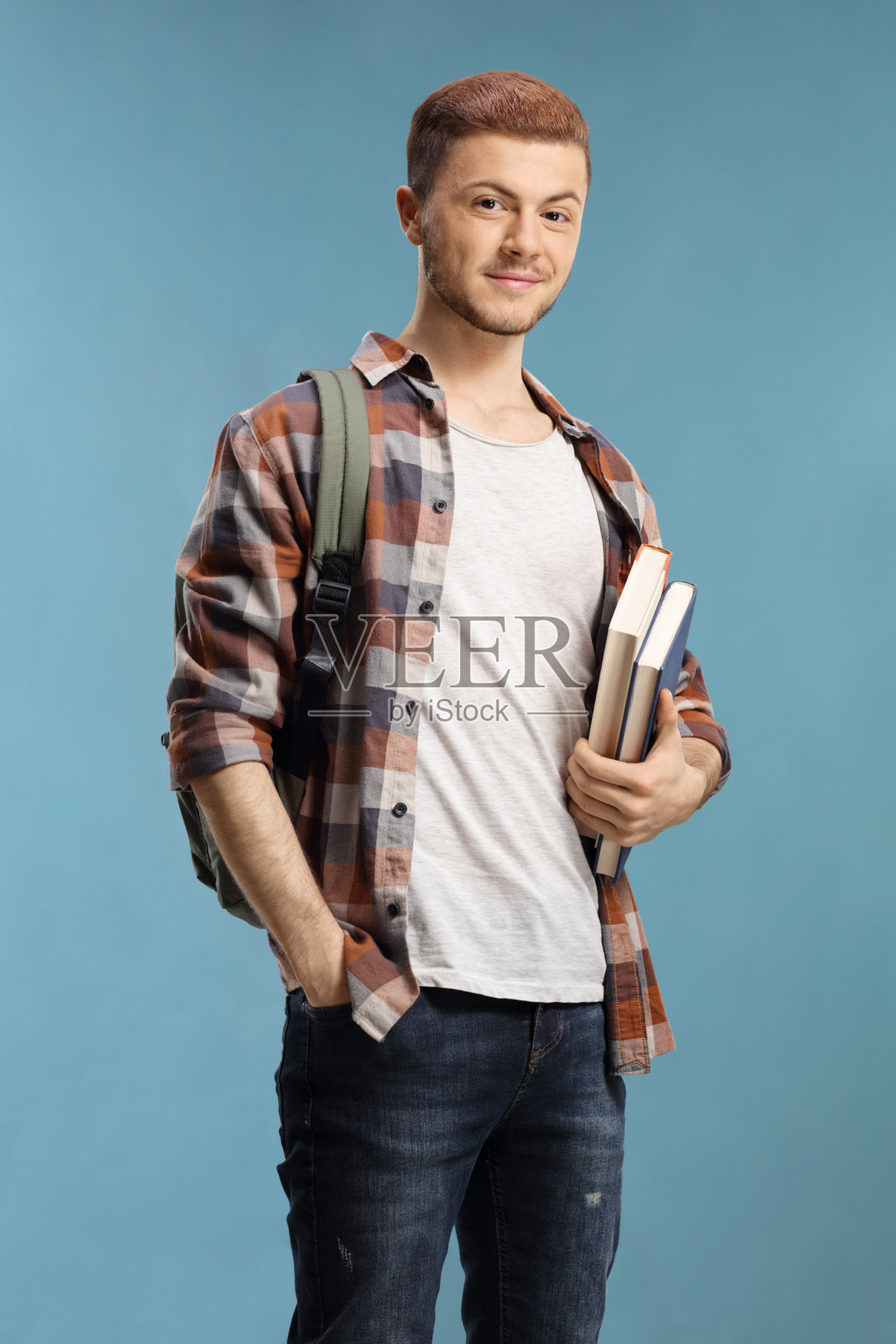 拿着书和背包的男学生照片摄影图片