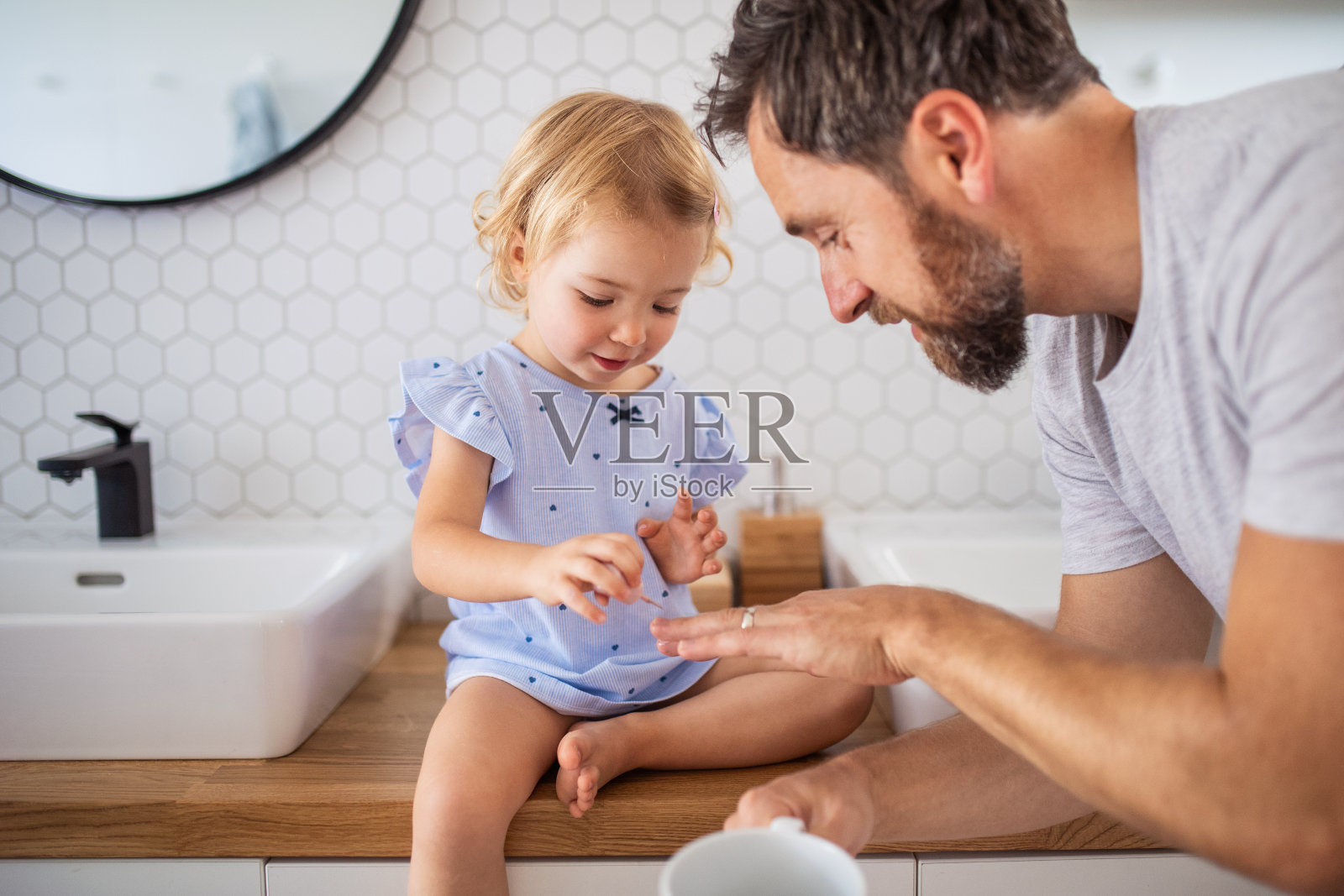 父亲和小女孩在室内浴室里涂指甲油照片摄影图片