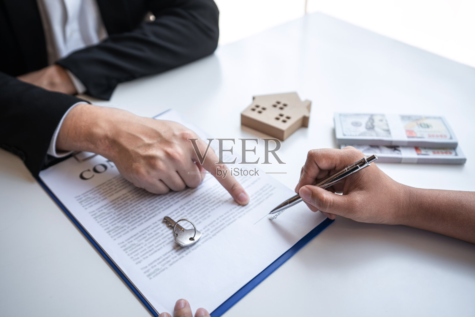 签订房屋购买合同,房地产经纪人展示房屋贷款,并在客户签署购房合同后交付钥匙照片摄影图片