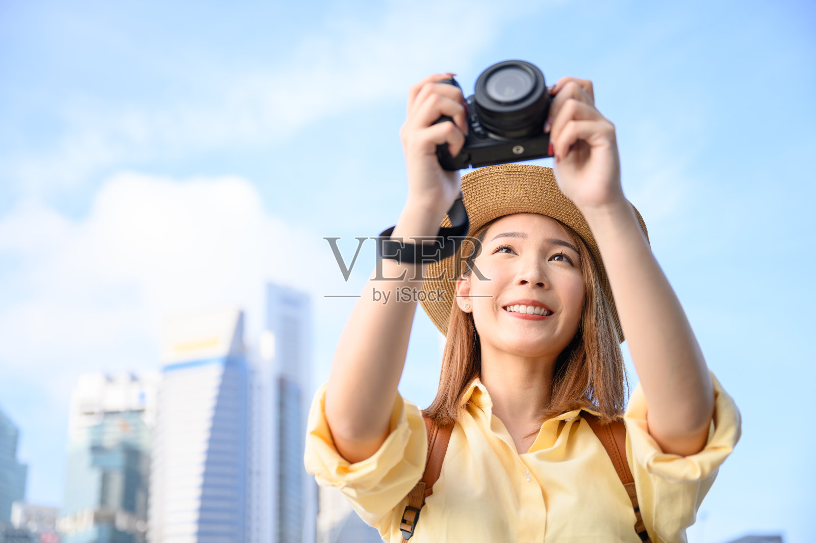 一名年轻女子在新加坡城市以建筑物为背景拍照照片摄影图片