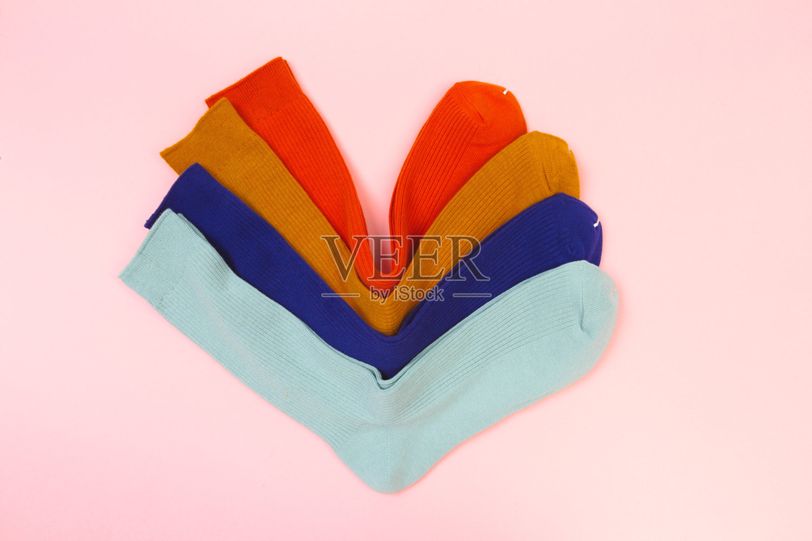 粉红色背景上的彩色袜子照片摄影图片