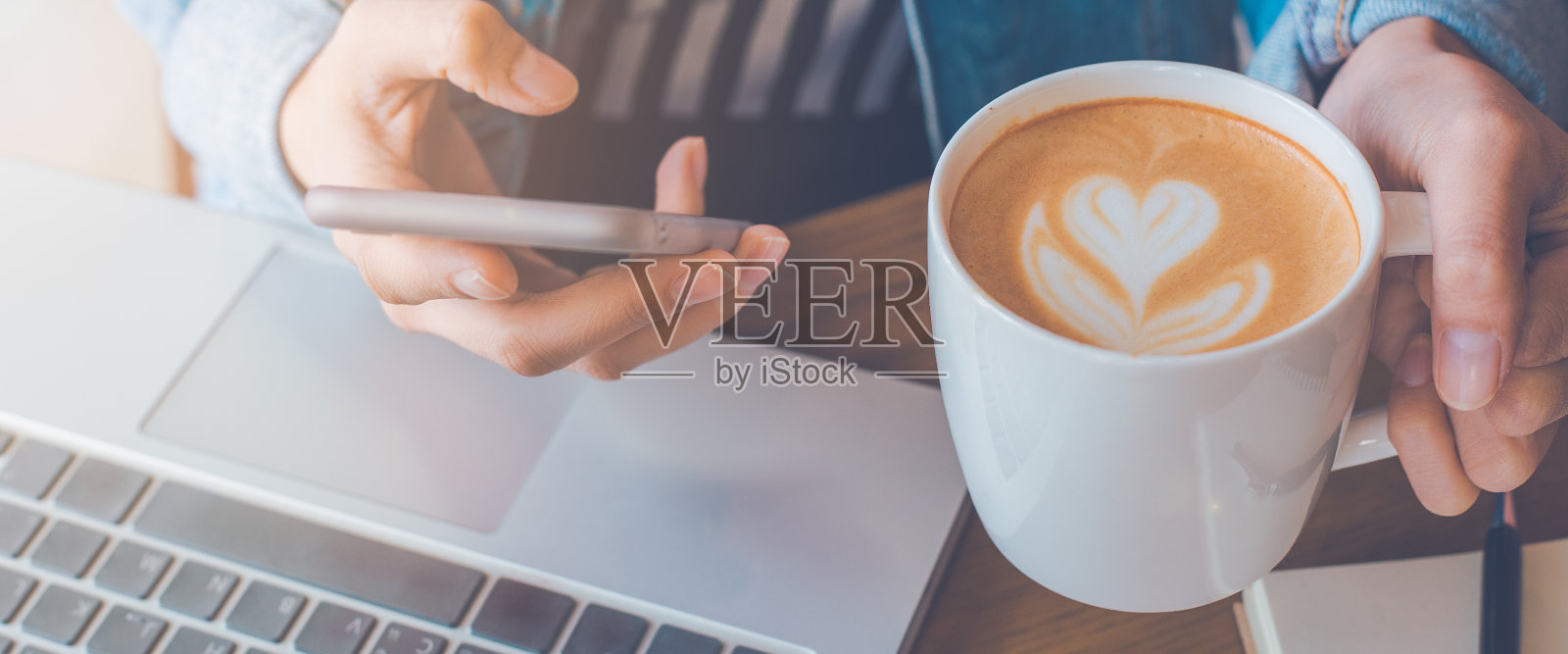 女人手拿咖啡杯并使用手机照片摄影图片