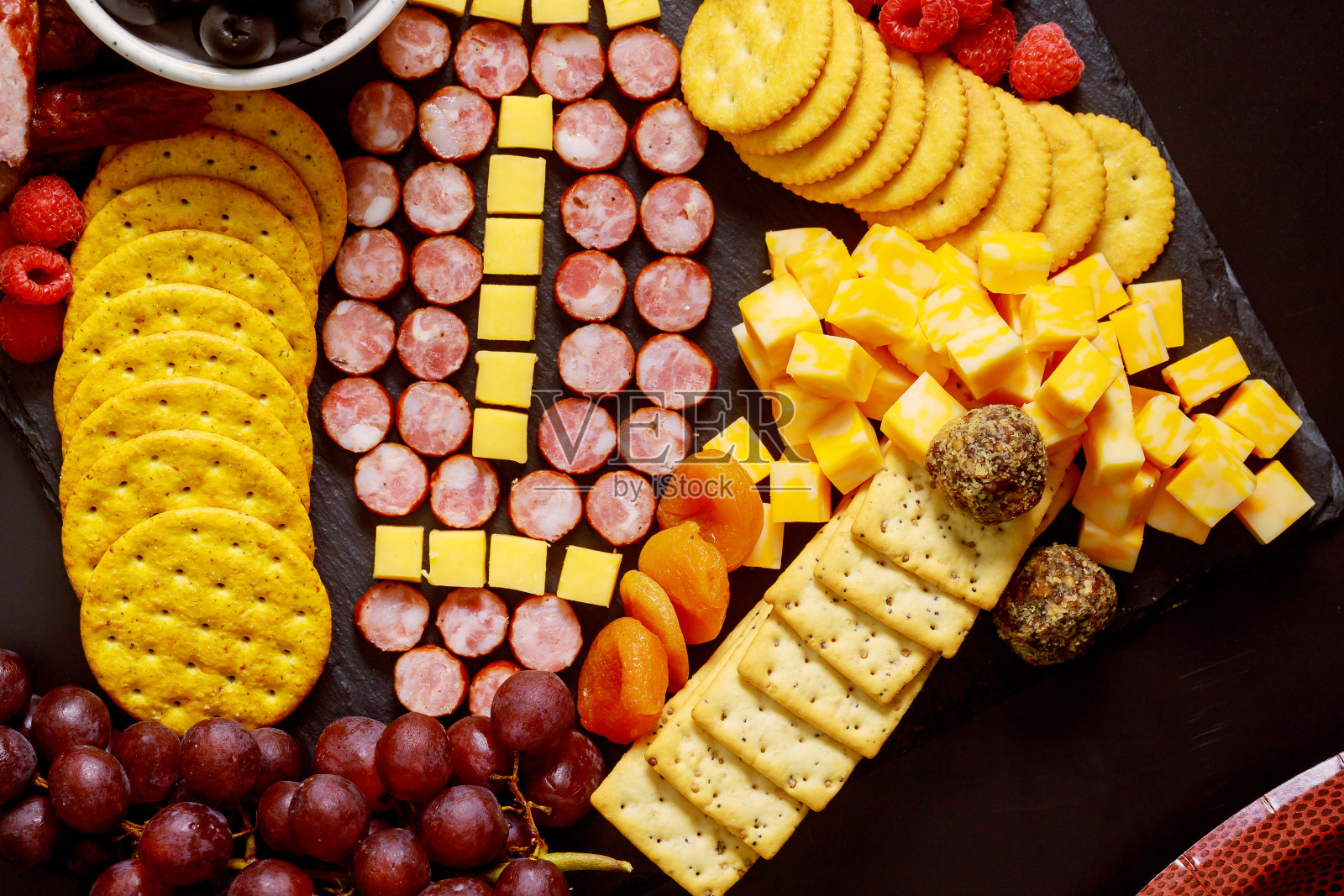 用奶酪和香肠制作的足球,用于烤肉板。美式足球比赛概念。照片摄影图片