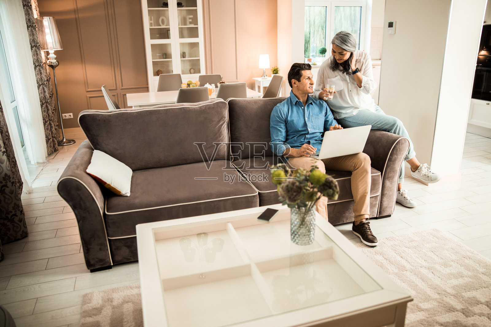 在客厅使用笔记本电脑的快乐成年男子照片摄影图片