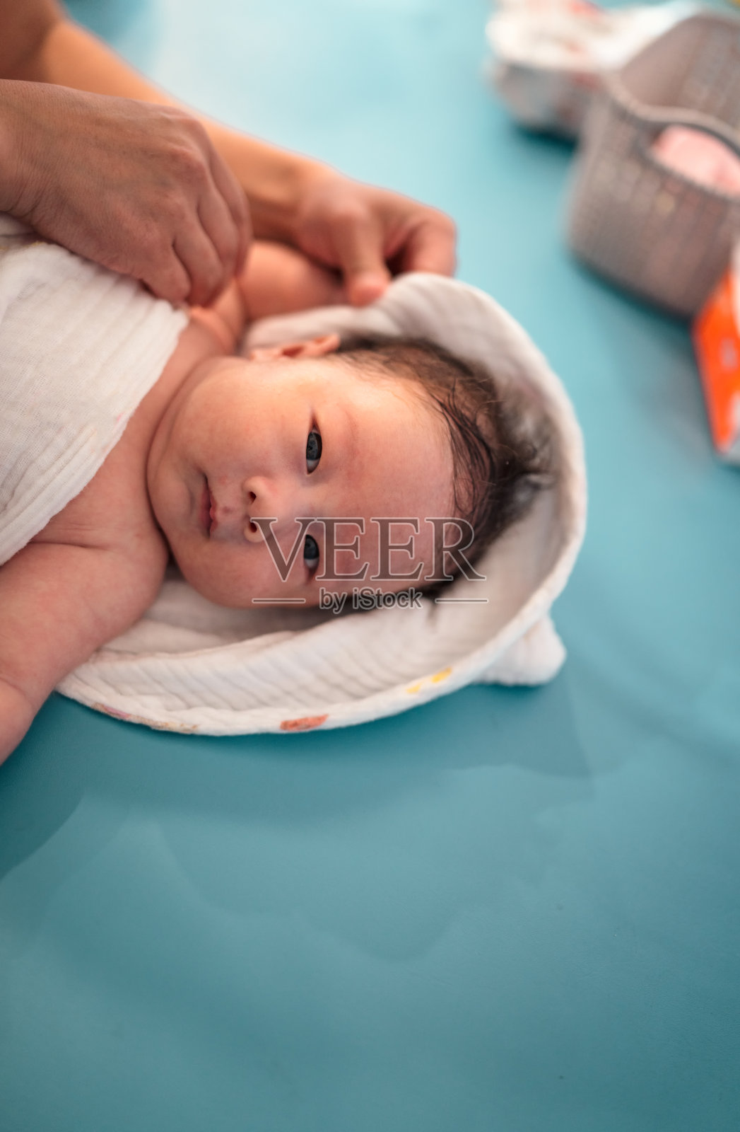 可爱的新生男婴沐浴后用毛巾用母亲的双手轻轻擦干身体照片摄影图片