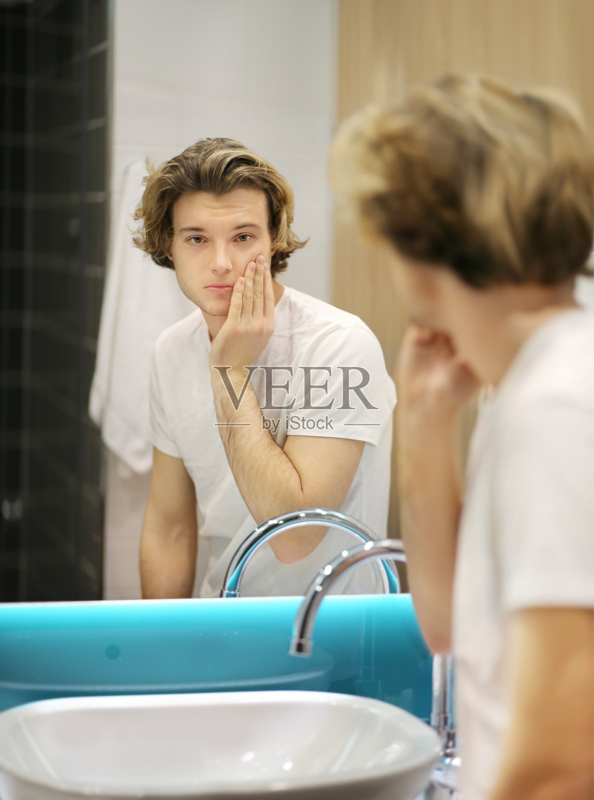 年轻人照镜子,梳头发,看看脸上的问题照片摄影图片