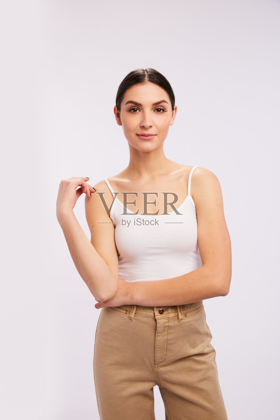 年轻的黑发女子自信地站在灰色背景下照片摄影图片