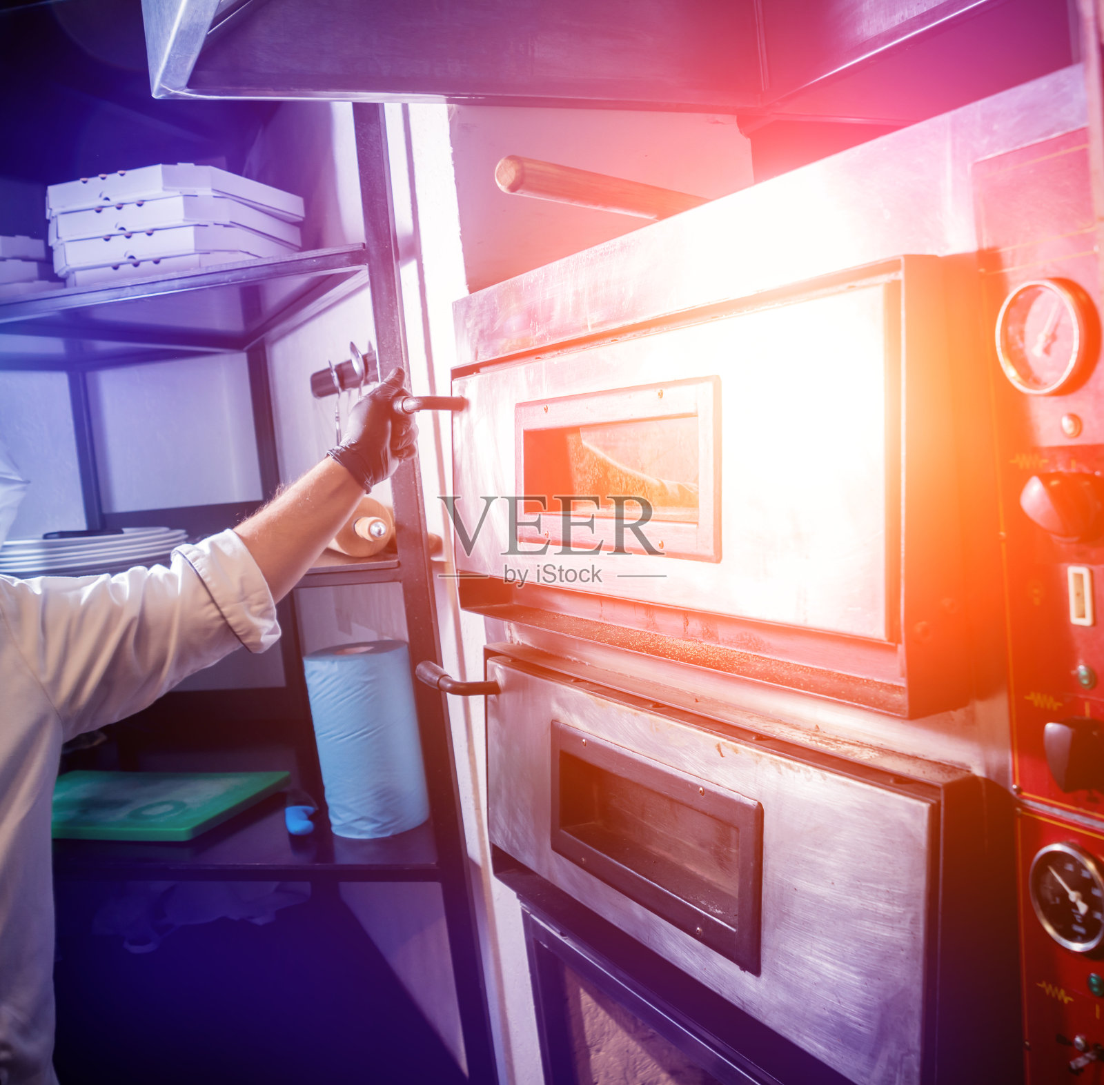 制作披萨的过程:厨师将生披萨放入烤箱。厨房照片摄影图片