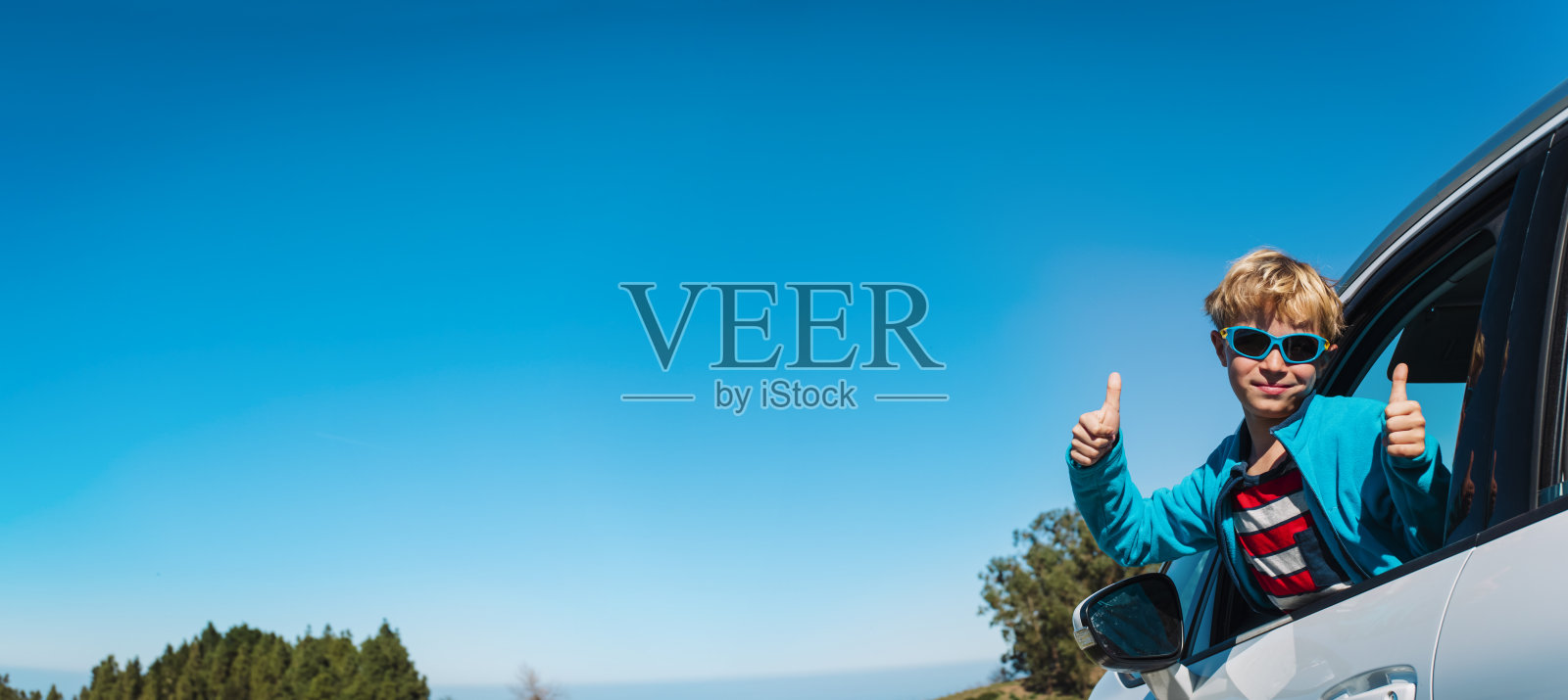 快乐的可爱男孩在乡间小路上驾车旅行照片摄影图片