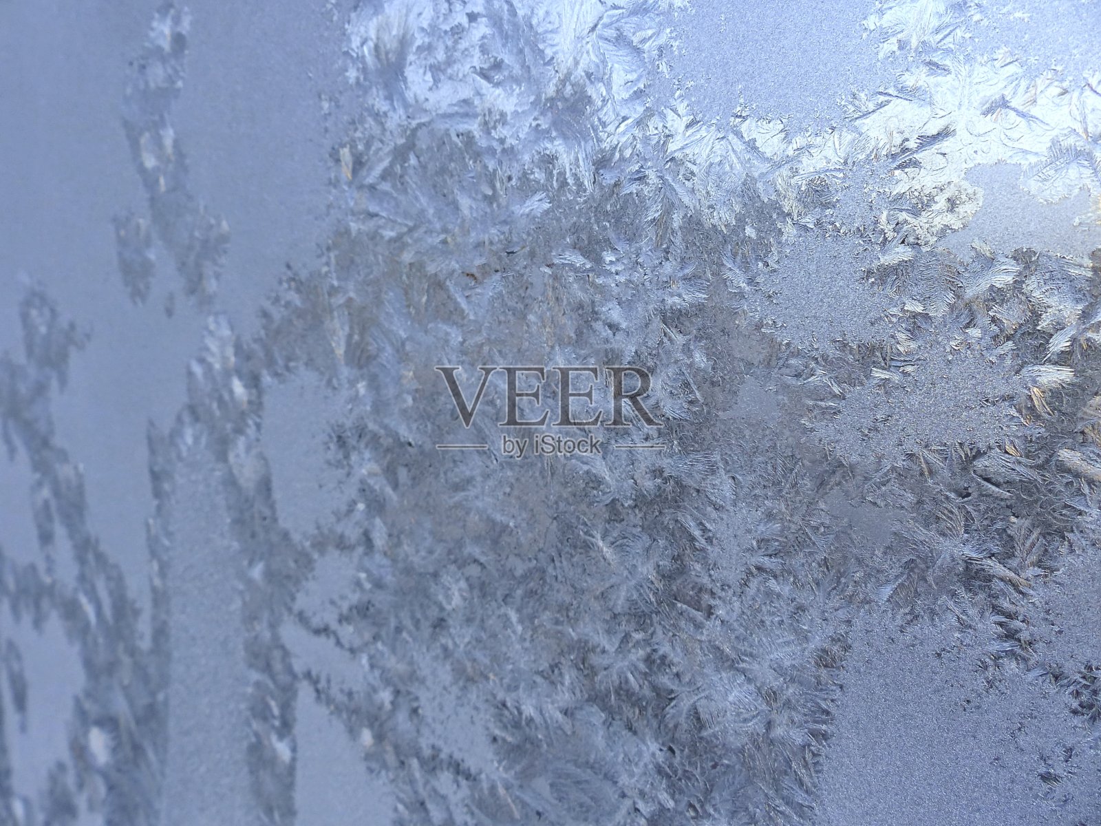 窗户上有霜冻的图案。自然吸引了。夜里结了严霜,窗户上布满了花纹。圣诞节和新年的创意背景。照片摄影图片