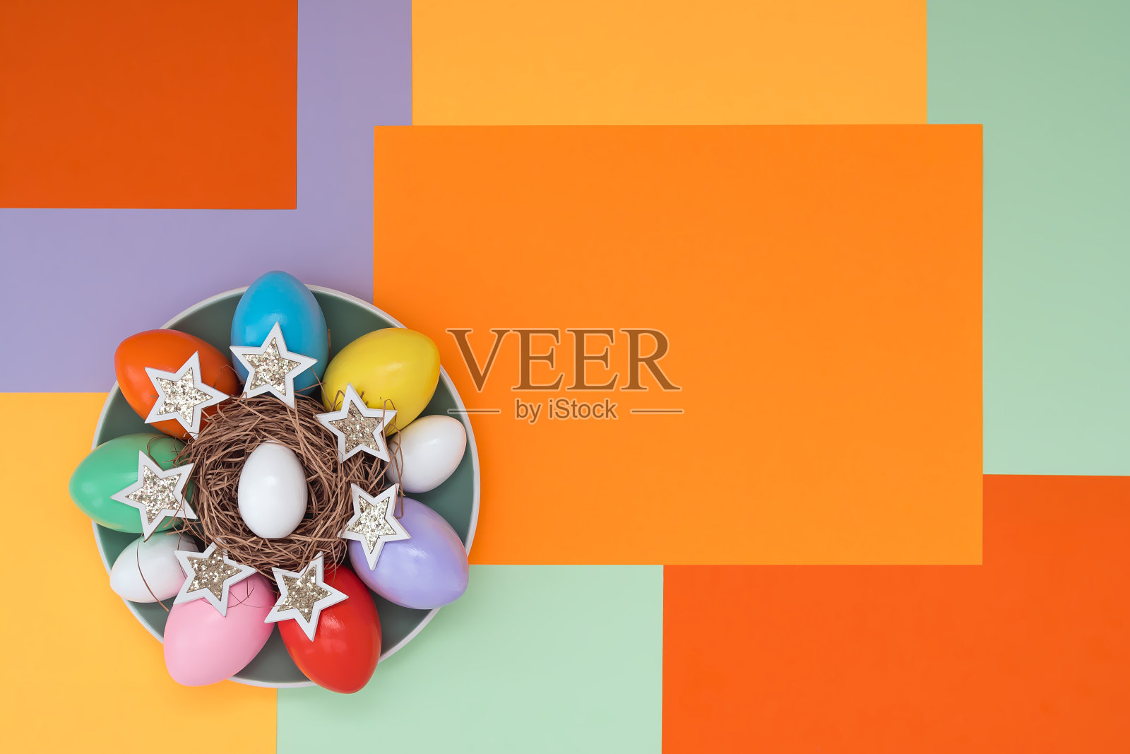 明亮的背景与非对称的几何图案,在一个时尚的配色方案与组成他们的复活节彩蛋和星星躺在一个盘子。概念背景、节日、复活节。照片摄影图片